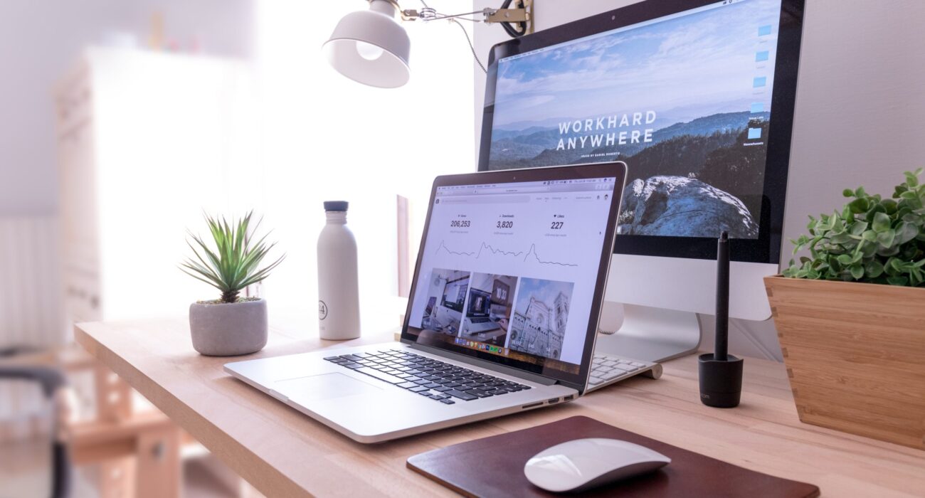 MacBook Pro on table beside white iMac and Magic Mouse
