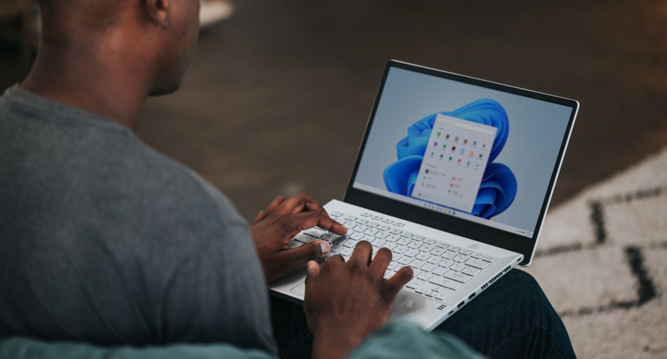 man in gray long sleeve shirt using Windows 11 computer
