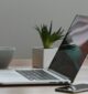 Free Minimalist home office desk with laptop, smartphone, and plant for a modern work environment. Stock Photo