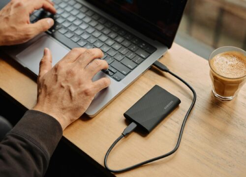 A man sitting at a table using a laptop computer